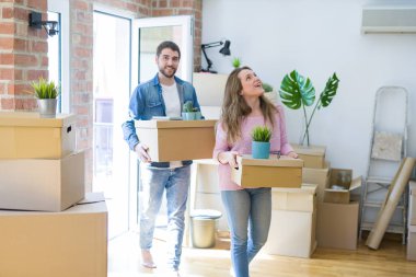 Yeni bir ev taşımak karton kutular tutarak birlikte çok mutlu genç güzel çift