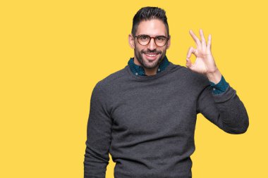 İzole arka plan el ve parmaklar ok işaretiyle yapıyor olumlu gülümseyen üzerinde gözlük takan yakışıklı delikanlı. Başarılı ifade.