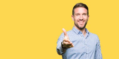 Mavi gözleri ile yakışıklı iş adamı tebrik ve davetkar olarak dostu sunan el sıkışması gülümsüyor. Başarılı iş.