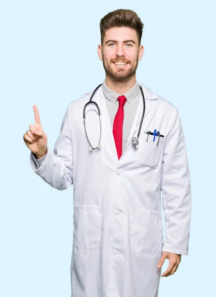 Mladý Pohledný Doktor Muž Zobrazeno Lékařský Plášť Směřující Nahoru Prstem — Stock fotografie