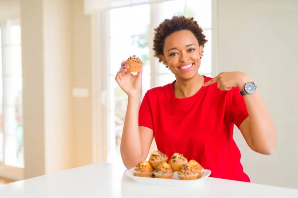 Joven Afroamericana Mujer Comer Chocolate Chips Muffins Con Cara Sorpresa — Foto de Stock