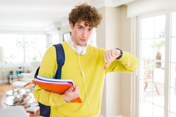 Joven Estudiante Con Auriculares Mochila Sosteniendo Cuadernos Con Cara Enojada —  Fotos de Stock