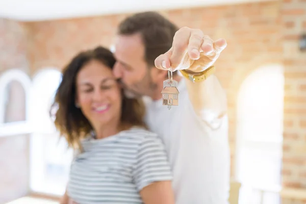 Romantisches Paar mittleren Alters, das Hausschlüssel hält und vorzeigt — Stockfoto
