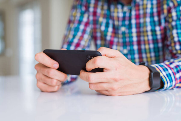 Close up of man hands using smartphone and smiling