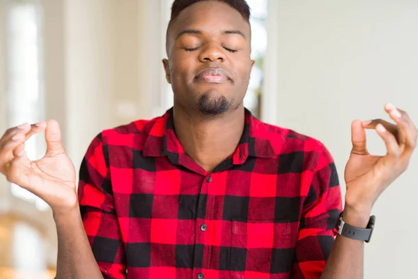 Handsome african american man relax and smiling with eyes closed doing meditation gesture with fingers. Yoga concept.