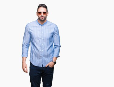 Genç yakışıklı adam yüzünde ciddi bir ifade ile izole arka plan üzerinde güneş gözlüğü takıyor. Basit ve doğal kameraya bakıyor.