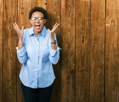 Genç güzel Afro-Amerikan iş kadın yüzünden arka plan deli kutluyor izole ve crazy arms ile başarı için kaldırdı ve heyecanlı çığlık gözler kapalı. Kazanan kavramı