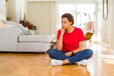 Evde oturan genç güzel Afrikalı Amerikalı kadın yorgun görünümlü ve çapraz silah ile depresyon sorunları ile sıkılmış düşünme.
