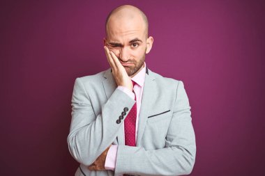 Genç iş adam elbise giyiyor ve mor izole arka plan üzerinde kravat yorgun bakıyor ve çapraz silah ile depresyon sorunları ile sıkılmış düşünme.