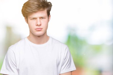 Sorunu nedeniyle izole arka plan şüpheci ve sinir, papatyanın üzgün üzerinde rahat beyaz t-shirt giyen genç yakışıklı adam. Negatif kişi.