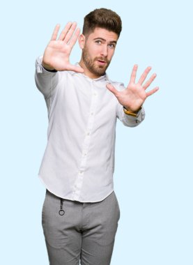 Genç yakışıklı iş adamı korkuyor ve korku ifade dur hareketi el ile ile dehşete şokta bağırarak. Panik kavramı.