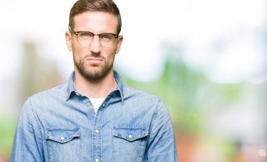 Gözlüklü, şüpheci ve gergin gözlük takan yakışıklı adam, sorun nedeniyle üzgün. Negatif kişi.