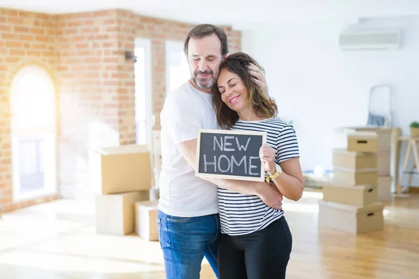 Casal sênior de meia-idade se mudando para uma nova casa, sorrindo feliz em — Fotografia de Stock