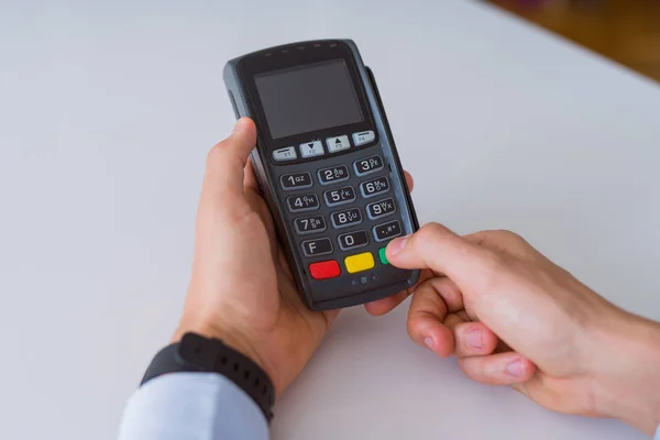 Fechar as mãos do homem segurando o terminal pos — Fotografia de Stock