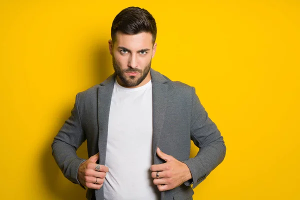 Joven hombre guapo posando y modelando sobre bac aislado amarillo —  Fotos de Stock