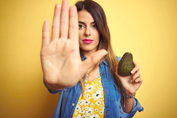 Giovane Bella Donna Mangiare Avocado Sano Sfondo Giallo Con Mano — Foto Stock