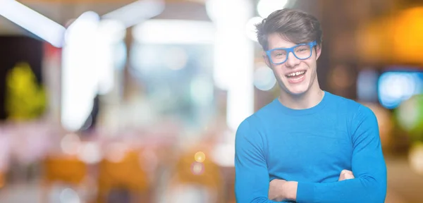 Mladý Pohledný Muž Který Nosí Modré Brýle Izolované Pozadí Usměje — Stock fotografie