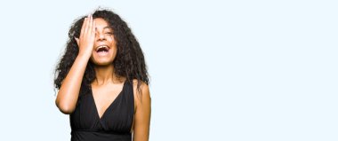 Kıvırcık saçlı Genç güzel kız yüz ve sürpriz duygu kendine güvenen gülümseme ile el ile bir göz kaplayan moda etek giyiyor.