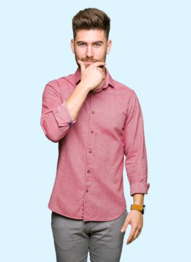 Genç yakışıklı iş casual adam emin çapraz kollar ve çeneme kaldırdı el ile gülümseme ile kameraya bakıyor. Pozitif düşünce.