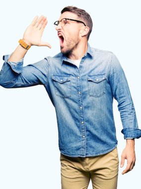 Bağırarak ve ağzı üzerinde el ile yan için çığlık gözlük takan yakışıklı adam. İletişim kavramı.