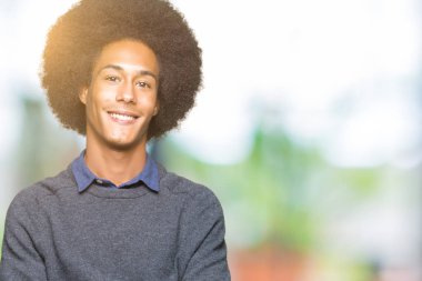 Afro saç mutlu yüz ile genç Afrikalı Amerikan iş adamı fotoğraf makinesi bakarak çapraz silah ile gülümsüyor. Pozitif kişi.