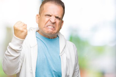 Üzerinde sweatshirt giyen orta yaş Arap adam arka plan kızgın izole ve kızgın yetiştirme hayal kırıklığı ve öfke ile bağırarak süre öfkeli yumruk. Öfke ve agresif kavramı.