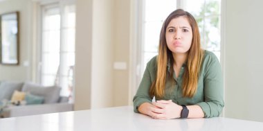 Evde güzel genç kadın komik yüzü ile yanakları şişirme. Ağız hava ile şişirilmiş, deli ifade.