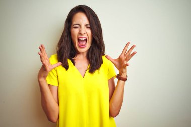 Beyaz izole arka plan üzerinde ayakta sarı t-shirt giyen genç güzel kadın deli ve silah ile başarı için deli kutluyor kaldırdı ve heyecanlı çığlık kapalı gözleri. Kazanan kavramı