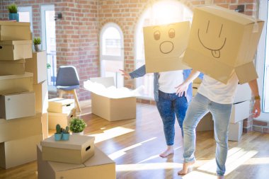 Komik emoji ile karton kutular giyen çılgın çift kafa üzerinde yüzler, yeni evde eğlenmek