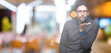 Bir öpücük el ile güzel ve seksi olmak hava üfleme kamera bakarak izole arka plan üzerinde gözlük takan yakışıklı delikanlı. Aşk ifade.