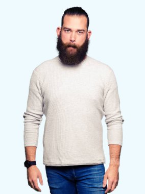 Rahat kazak giyen genç sarışın adam yüz ciddi ifade ile rahat. Basit ve doğal kamera bakıyor.