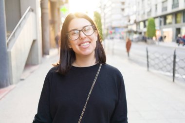 Güzel genç esmer kadın gülümsüyor heyecanlı yürürken 