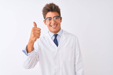 Genç yakışıklı sciencist adam gözlük ve ceket izole beyaz arka plan üzerinde el ile jest kadar mutlu başparmak yapıyor giyiyor. Başarı gösteren kameraya bakarak ifadeyi onaylama.