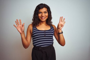 Transseksüel transseksüel kadın izole beyaz arka plan üzerinde çizgili t-shirt giyiyor ve parmak numarası dokuz ile işaret kadar kendine güvenen ve mutlu gülümseyen.