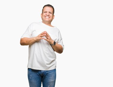 Orta yaş Arap adam wearig rahat ve neşeli gülümseyen beyaz t-shirt üzerine izole arka plan el ele tutusun ve parmak çarpı işareti. Başarı ve iyimser