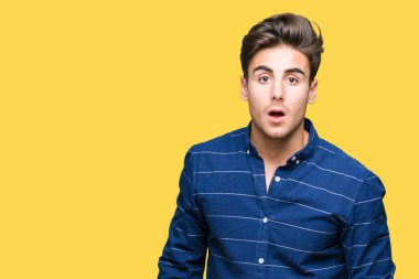 Yakışıklı delikanlı izole arka plan korkuyor ve şok sürpriz ifade, korku ve heyecan yüz üzerinden Donanma gömlek giymiş.