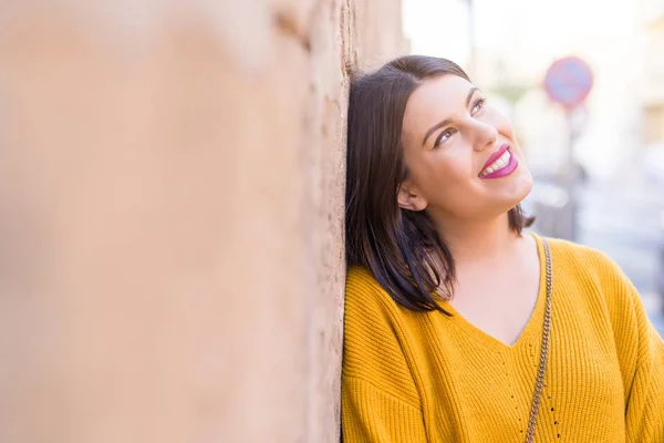 Hermosa joven mujer sonriendo confiada y alegre apoyándose en — Foto de Stock