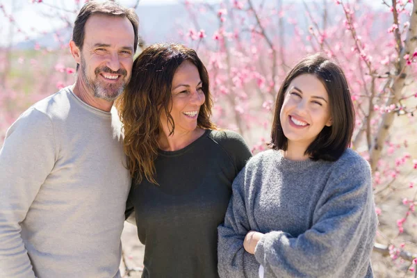 Üç gülümseyen neşeli ve şeftali üzerinde sarılma güzel aile 