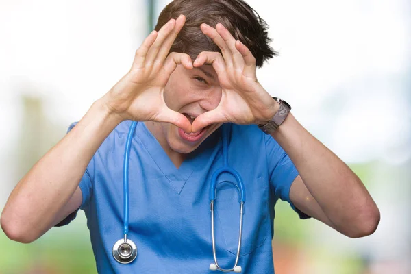 分離の背景手と指の標識を見て笑みを浮かべて行うハートの上医療制服を着て若い医者 — ストック写真