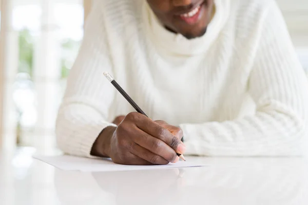 Close Van Afrikaanse Man Schrijven Een Briefje Een Papier Glimlachend — Stockfoto