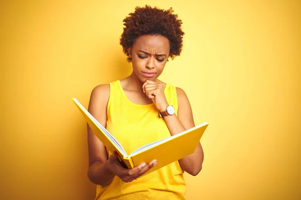 Afrikansk Amerikansk Kvinna Läser Bok Över Gula Isolerad Bakgrund Allvarligt — Stockfoto