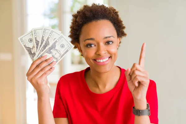 달러의 지폐를 아프리카 미국인 여성은 행복한 손가락을 가리키는 아이디어 질문으로 — 스톡 사진