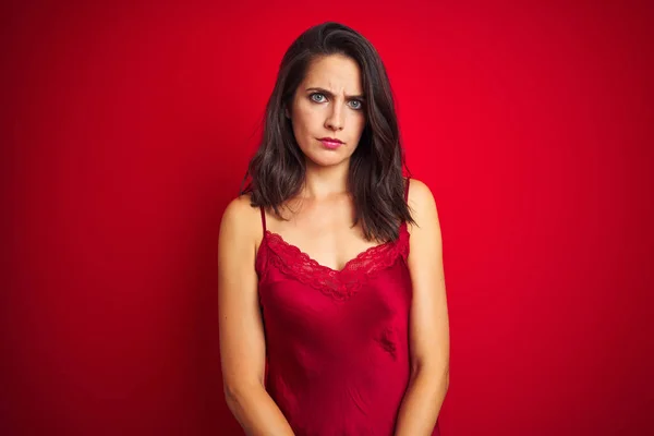 年轻美丽的女人穿着性感内衣在红色孤立的背景怀疑和紧张 皱眉不安 因为问题 消极的人 — 图库照片