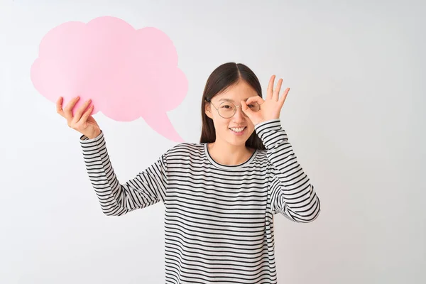 年轻的中国妇女拿着云语音泡沫在孤立的白色背景与快乐的脸微笑做Ok标志手在眼睛通过手指看 — 图库照片