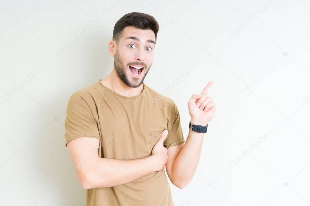 Young handsome man over isolated background with a big smile on face, pointing with hand and finger to the side looking at the camera.