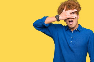 Genç yakışıklı zarif adam afro saç şok kapsayan yüz ve gözleri el ile göz, utanmış ifade ile parmaklar bakarak.