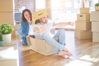 Komik ve çılgın çift bir araba olarak bir cardboad kutusu sürme eğlenceli sahip, mutlu gülümseyen ve yeni evde gülüyorsun