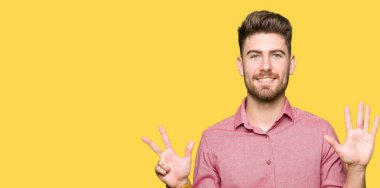Gösterilen ve parmakları ile işaret genç yakışıklı iş casual adam kendinden emin ve mutlu gülümseyerek süre sekiz numara.