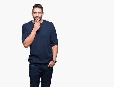 Emin çapraz kollar ve çeneme kaldırdı el ile gülümseme ile kameraya bakarak izole arka plan üzerinde kazak giyen genç yakışıklı adam. Pozitif düşünce.