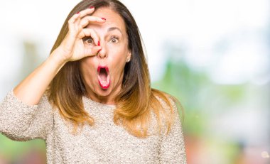 Moda kazak giyen güzel orta yaş kadın sürpriz yüz ile şok ok jest yapıyor, göz parmaklar bakarak. İnanılmaz ifade.